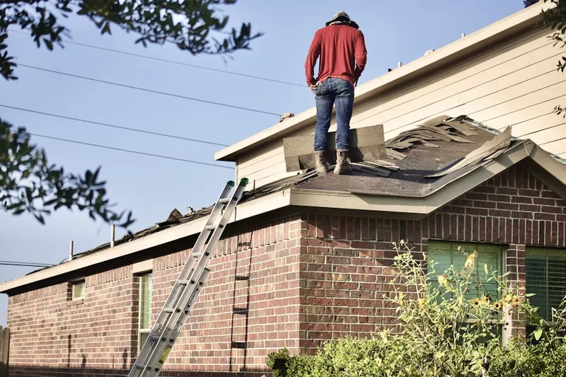 Professional roofer working on a residential roof in Schoeneck